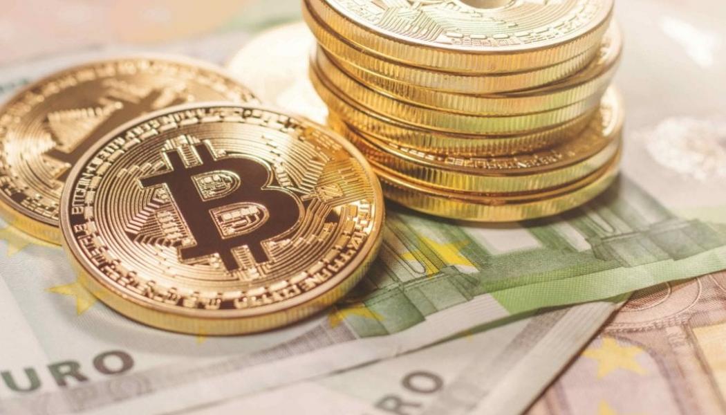 Gold coins with Bitcoin logo stacked on Euro bills